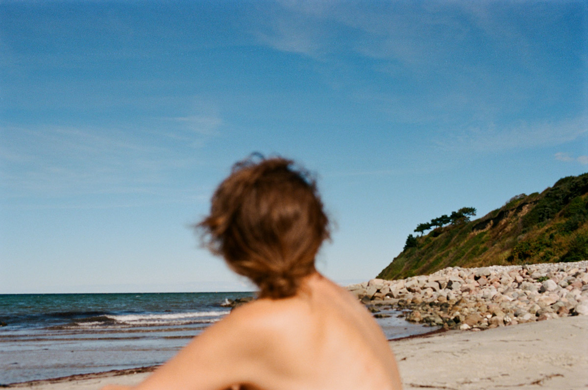 Portræt af Kristina Demant ved havet, fotograferet på analog film af Gyrithe Lemche.